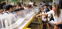 Students cluster around a long clear acrylic tank