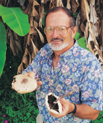 Don Hemmes holding palm-sized caps of two mushrooms