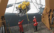 scientists hoisting gear in an icy environment, click for story