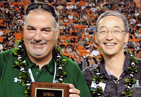 two men on football field with lei