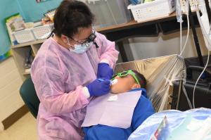 A student receiving care from a dental service provider.