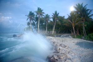Waves crashing over roadway in Temwaiku, Kiribati. Credit, Annika Dean.