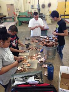 Sheetmetal students handcrafting copper roses.