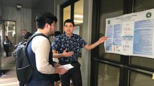 Public health junior Robert Nieto explains his literature review on ethnic dispraise in obesity with a student peer.