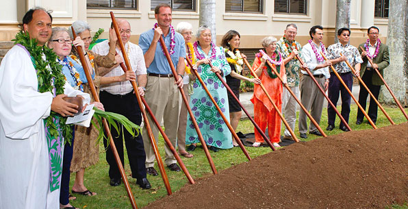 group of people with stick in dirt