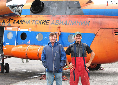 Two men in front of a helicopter