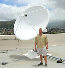 Man standing in front of satellite dish
