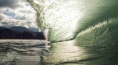 inside of a breaking wave with light shining through the crest