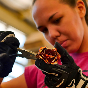 student shaping metal rose