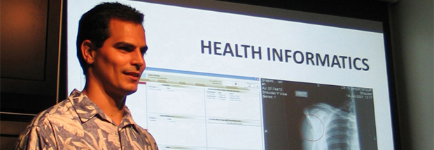 Man standing in front of a health informatics screen