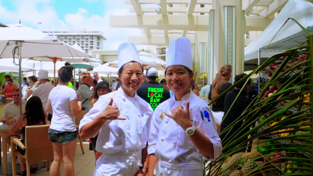Two culinary students flashing shaka at an event