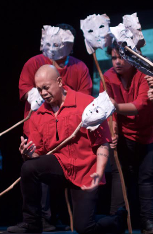 actors in red with white masks rehearsing