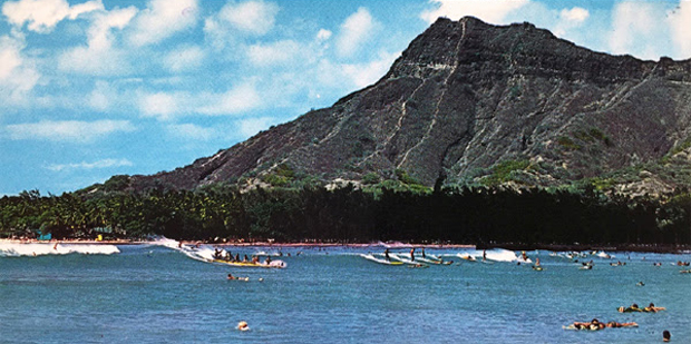 reversed view of Diamond Head with surfers and canoes on waves