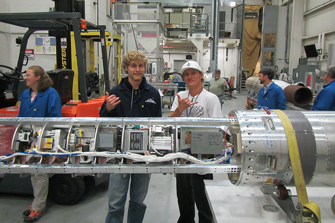 Two students flashing shaka with the integrated payload
