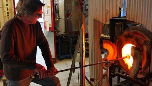 Rick Mills heats glass in a furnace