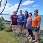 Project team members standing next to Punaluʻu ocean