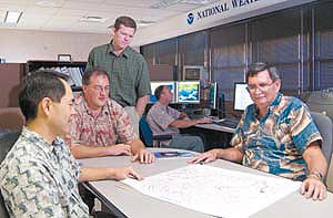 group of men studing charts and computers
