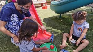 Early educator observing the activities of two toddlers at the UH Mānoa Children’s Center