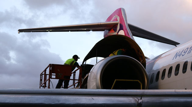 Two workers on a Hawaiian Airlines plane