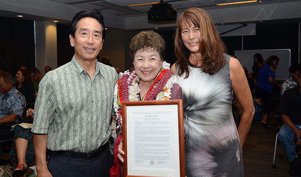 Ching holding framed certificate of honors