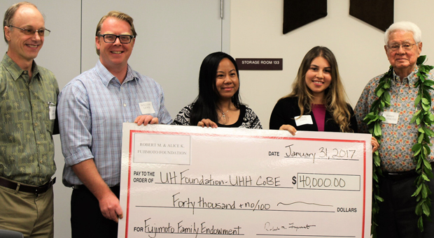 five people holding big check