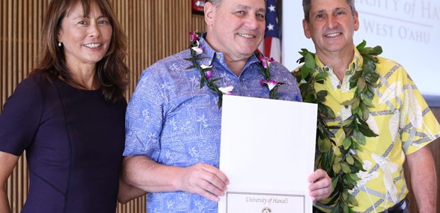 three people with a certificate