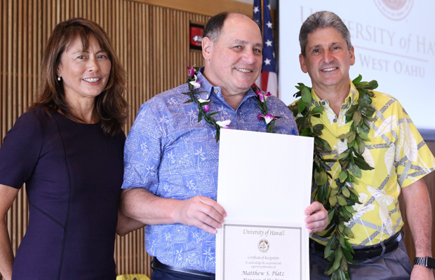 three people with a certificate