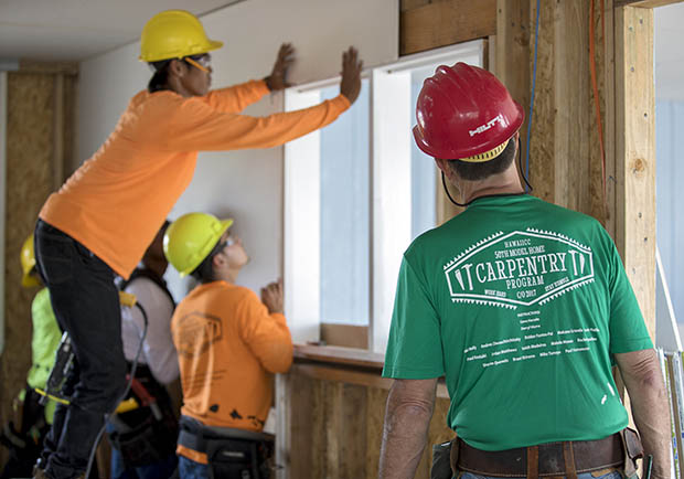 Students work on the interior of a model home