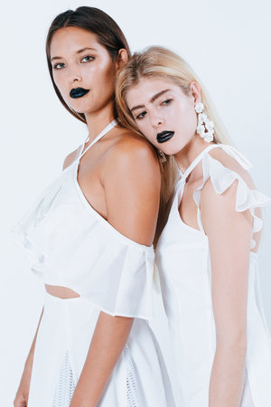 LUMIÈRE Promotional photo: two models dressed in white with black lipstick
