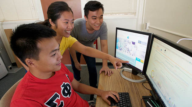 Students around two computer screens