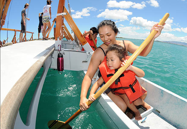 Woman and child in a life vest holding a paddle