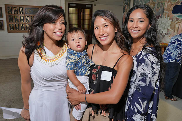 Three smiling women and a baby