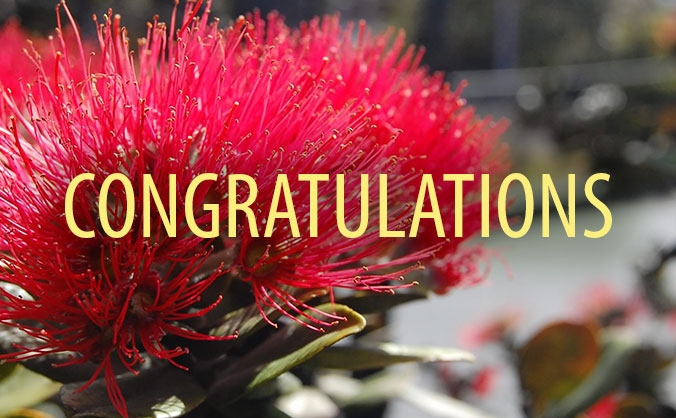 The word ʻcongratulationsʻ in front of a flower