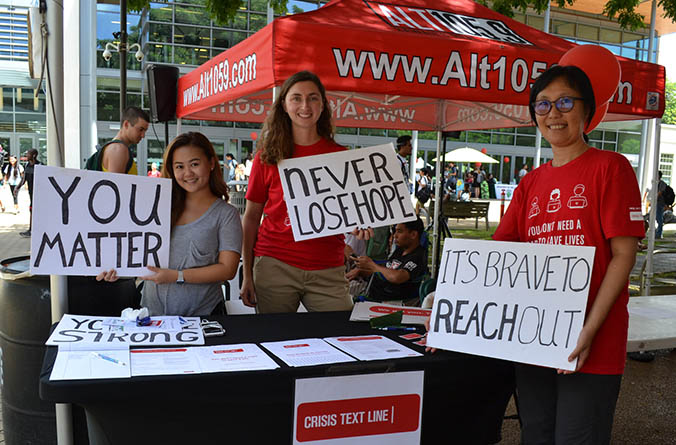 Smiling people holding signs with encouraging messages