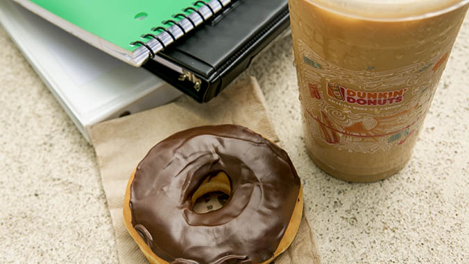 Donut, iced coffee and notebooks