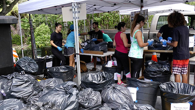 Students sorting through many bags of trash