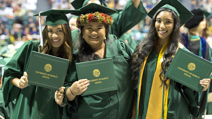 3 University of Hawaii at Manoa graduates in cap and gown