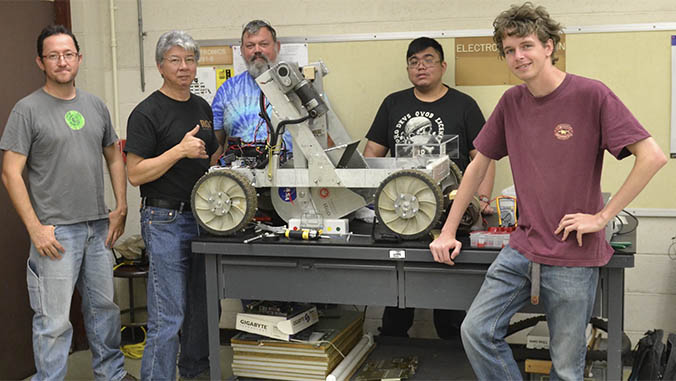 Instructors and students with finished electronics project