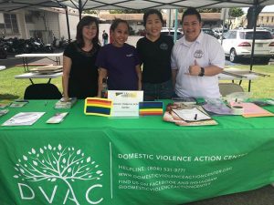 Volunteers smiling at the Domestic Violence Action Center info table