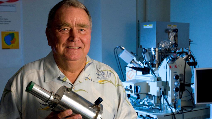 Klaus Keil in his lab holding an energy dispersive spectrometer