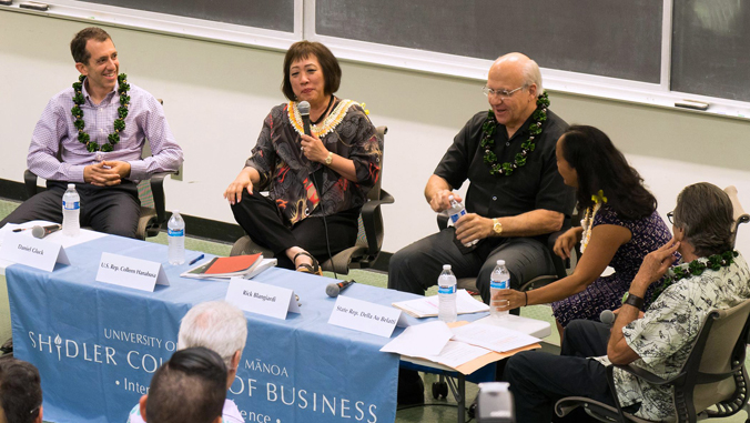 five people sitting behind a table talking to an audience