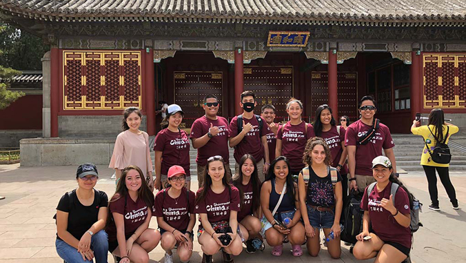 group of students in front of a historic building in China