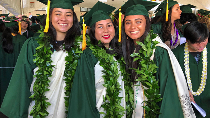 3 graduating student at commencement wearing their kihei