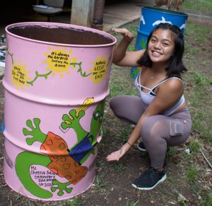 girl posing with decorated garbage can