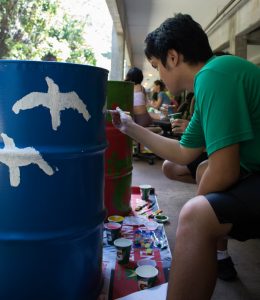 student painting garbage can