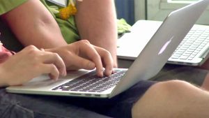 hands typing on laptop