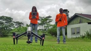 Two people in a field with a drone. Click image for larger version