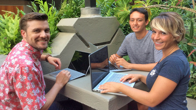 three law students sitting at a table with their laptops