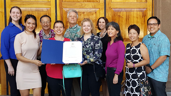 Smiling people holding a proclamation