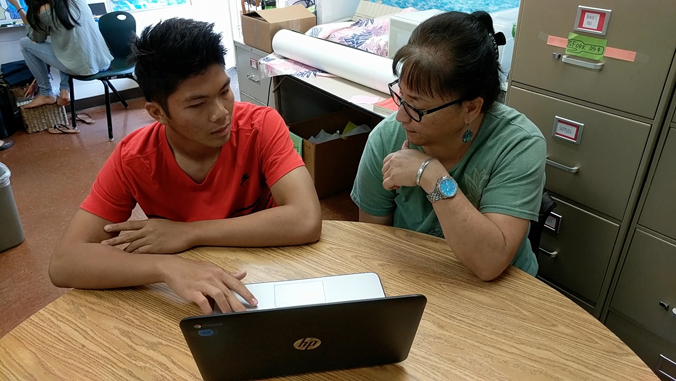 Student with counselor looking at a laptop